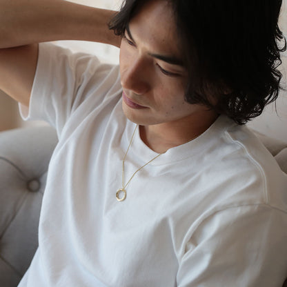 メビウスの輪のネックレスを着けた男性